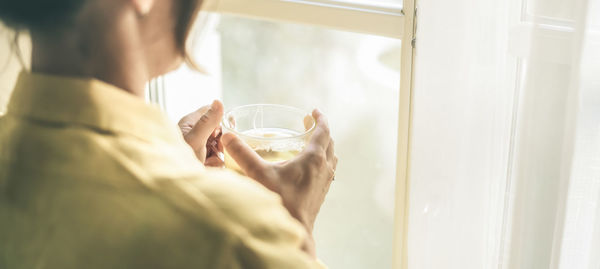 Cropped hands of woman holding glass