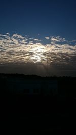 Silhouette buildings against sky at sunset