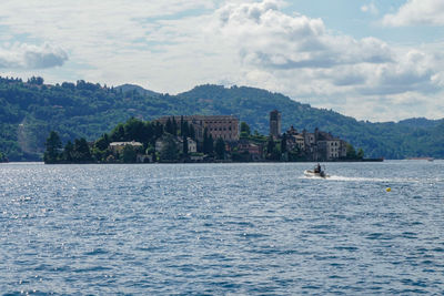 View of orta lake with san giulio island with nautical dinghy