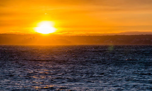 The setting sun envelops a ship on the puget sound.