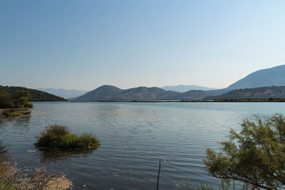 Scenic view of lake and mountains against clear sky