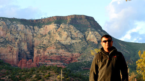 Man standing against rocky mountain