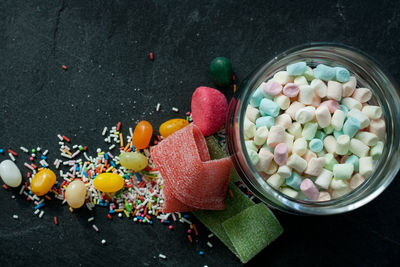 Sweets and marshmallows in a glass on slate 