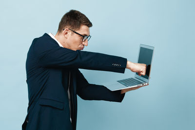 Side view of businessman using laptop at office