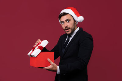 Mid adult man wearing hat against red background