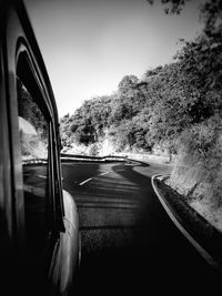 Car on road by trees against sky