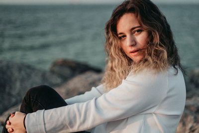 Side view of young woman against sea