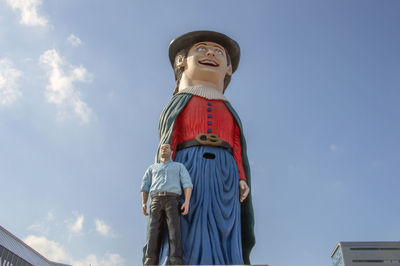 Low angle view of statues against blue sky