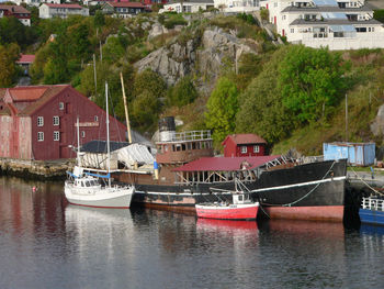 Boats moored in river by buildings in city