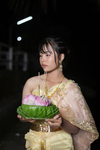 Portrait of young woman holding christmas tree