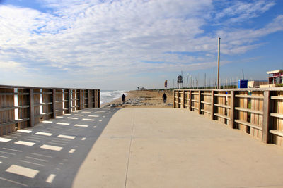 View of pier on beach against sky