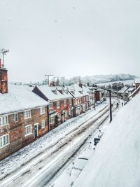 High angle view of snowy houses against sky