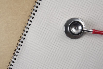 Directly above shot of stethoscope on spiral notebook