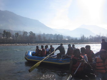 Panoramic view of people on lake against sky