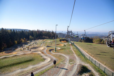 High angle view of road amidst trees against clear sky