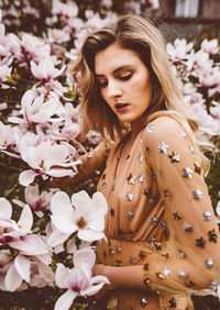 Young woman amidst pink flowers during springtime