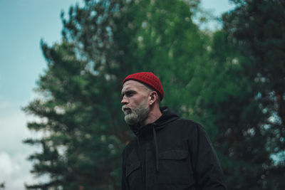 Portrait of man looking away against trees during winter