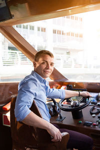 Portrait of a smiling young man sitting in bus