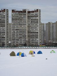 People in city against sky during winter