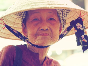 Portrait of senior woman wearing asian style conical hat