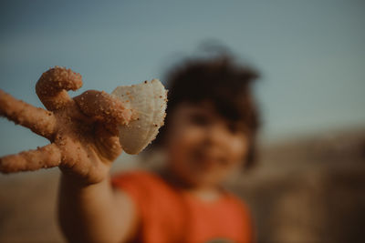 Close-up portrait of boy against sky