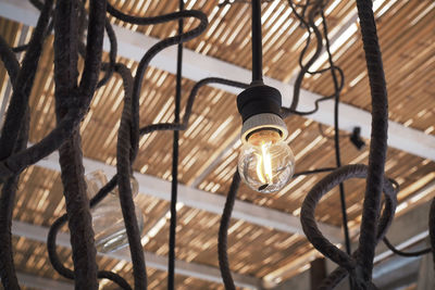 Close up image of light bulb, hanging from wooden ceiling