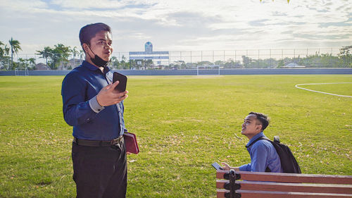 Full length of man using mobile phone in park