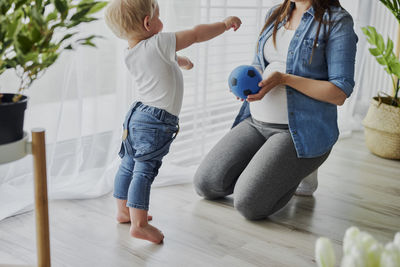 Rear view of mother and daughter on floor