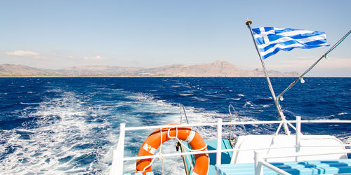 Boat sailing on sea against blue sky