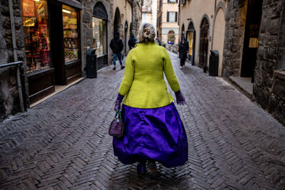 Rear view of woman walking on street in city