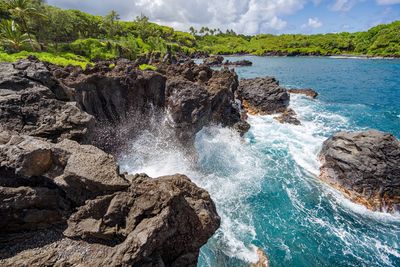 Rocks in sea against sky