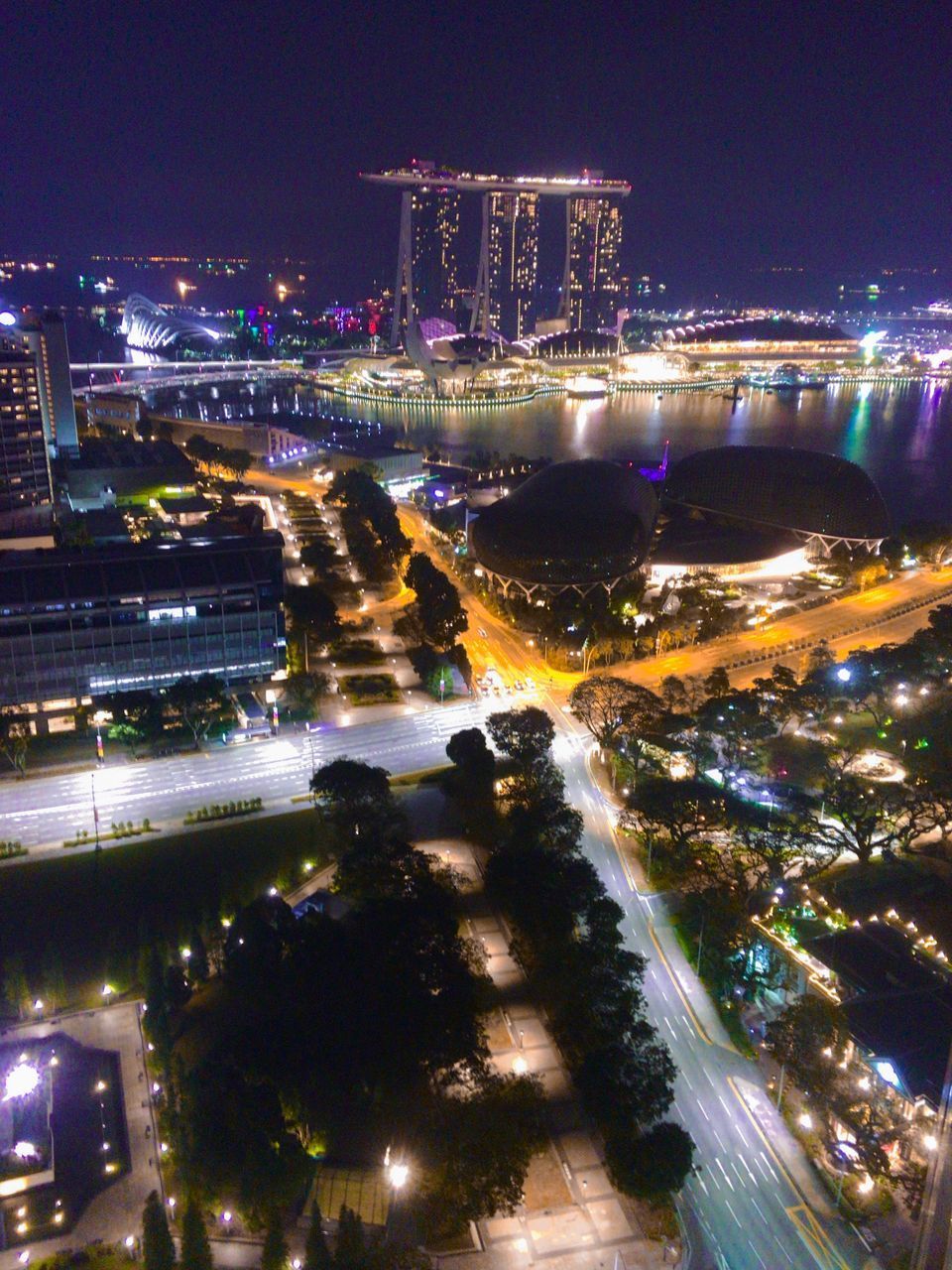 HIGH ANGLE VIEW OF ILLUMINATED MODERN BUILDINGS IN CITY AT NIGHT