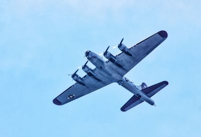 Low angle view of bomber plane against blue sky