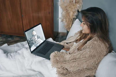 Young woman talking to doctor on video call at home