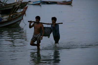 Rear view of men on boat in lake