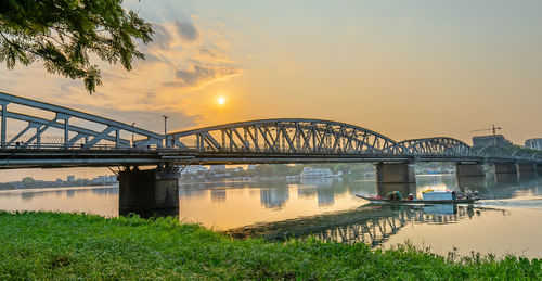 Bridge over river against sky during sunset