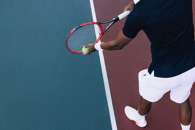 Midsection of man playing tennis