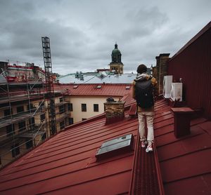 Man standing in city against sky
