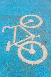 High angle view of bicycle symbol on blue street