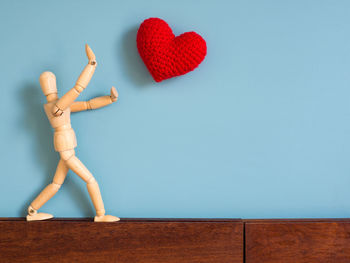 Heart shape on table against wall