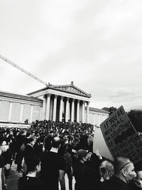 People on street against sky in city