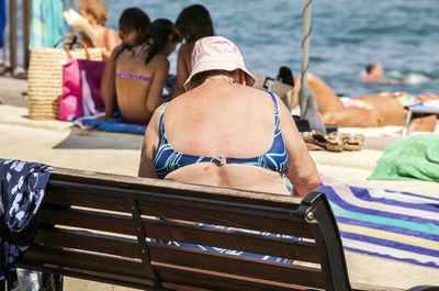 Rear view of woman sitting on bench