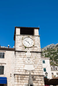 Low angle view of clock tower against clear blue sky