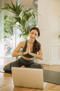 Young woman sitting on sofa at home