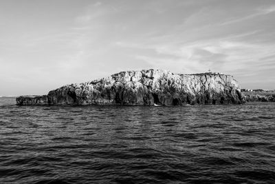Scenic view of rock formation in sea against sky