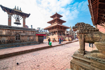 People at temple against building