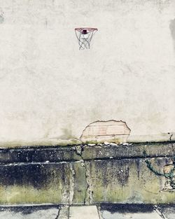 Low angle view of basketball hoop on weathered wall