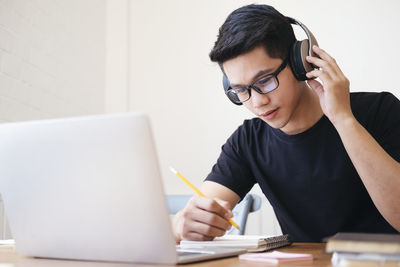 Young collage student using computer and mobile device studying