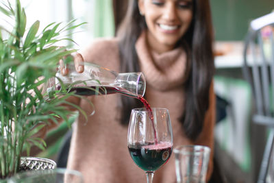 Close-up of a smiling young woman holding drink