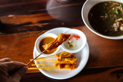 Midsection of person having food in plate